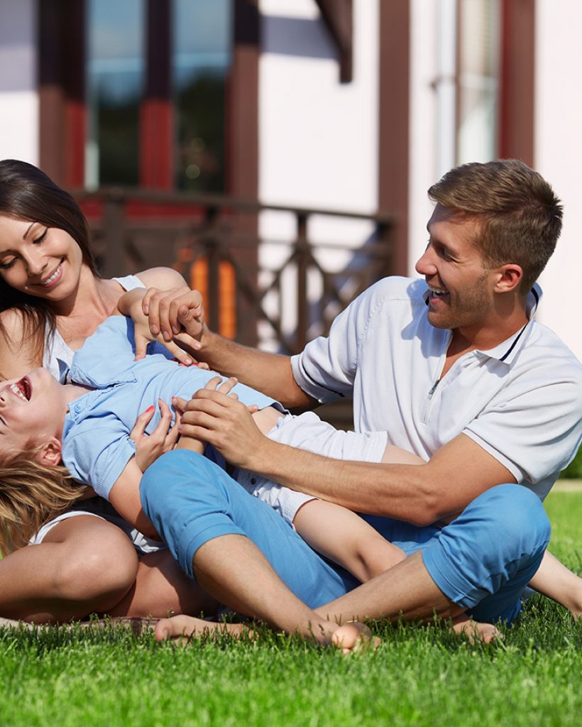 Family with a child playing on a lawn